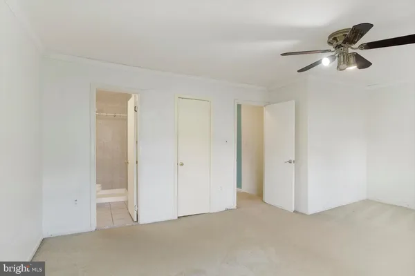 a view of an empty room and chandelier fan