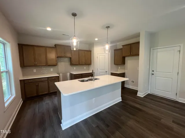 a kitchen with a sink a counter top space stainless steel appliances and cabinets