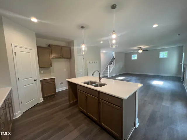 a kitchen with stainless steel appliances granite countertop a sink a stove and a wooden floors