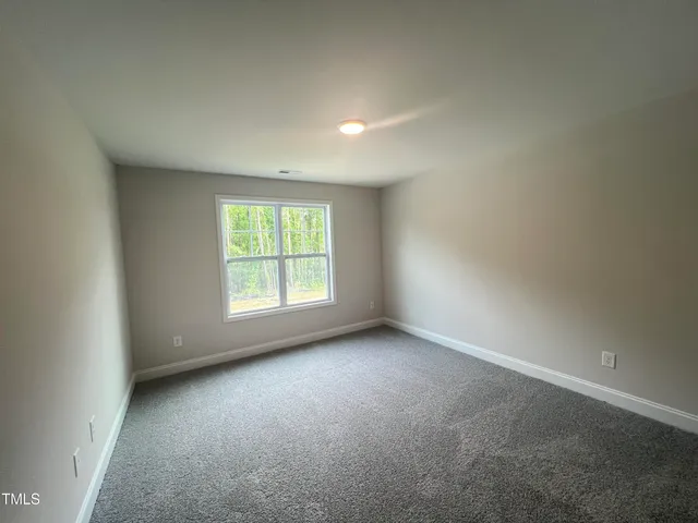 an empty room with windows and chandelier fan