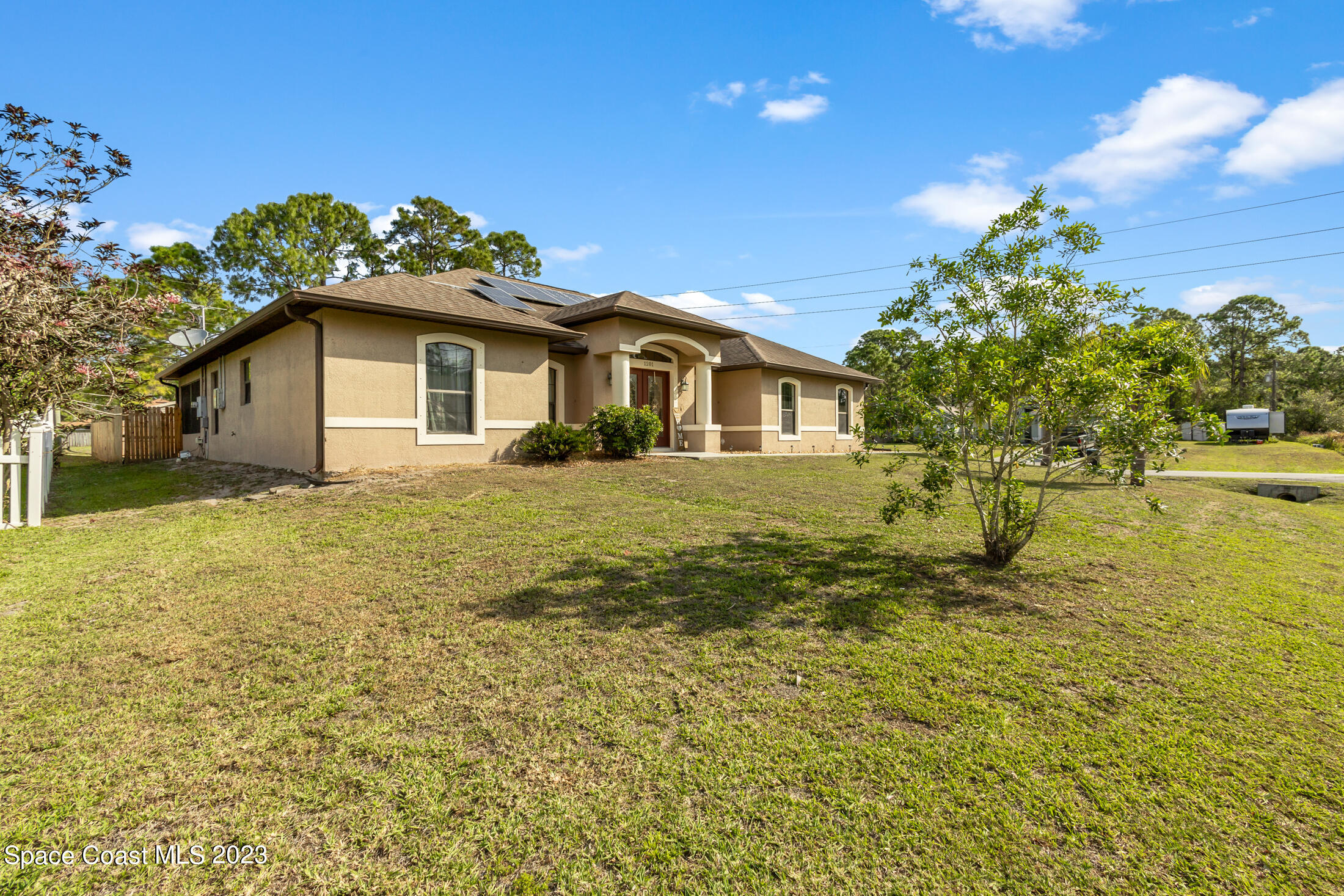 1201 Daton Road Southwest Palm Bay, FL 32908 - Photo 6 of 46 a white house that has a tree in front of it