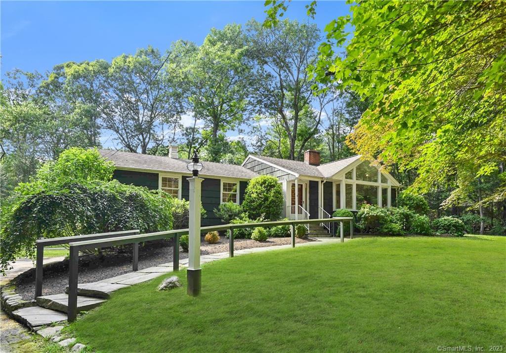 a view of a house with backyard and a tree