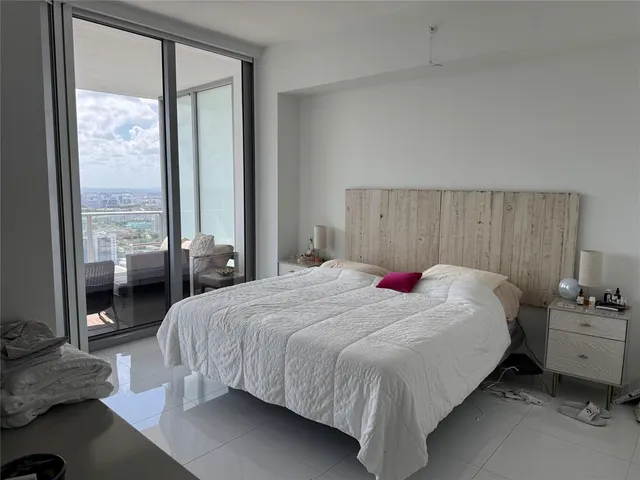 a bedroom with a bed and large window