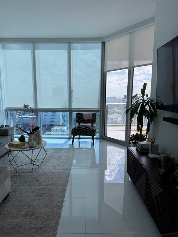 851 Northeast 1st Avenue, Unit 2606 Miami, FL 33132 - Photo 4 of 30 a living room with furniture and a flat screen tv