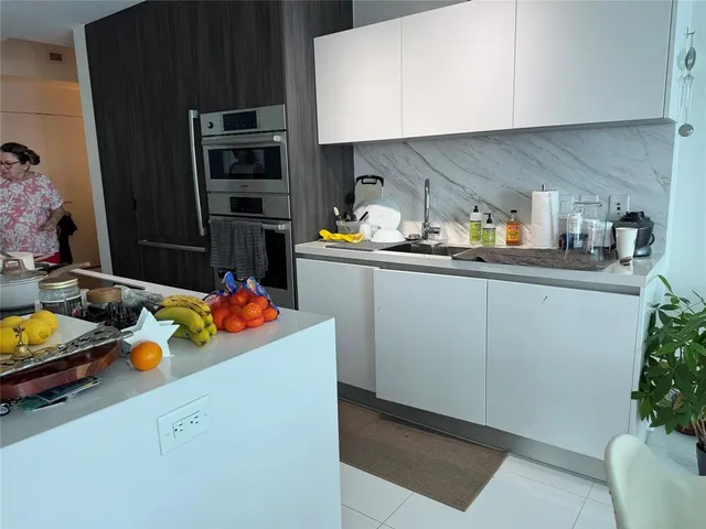 a kitchen with a sink a stove and cabinets