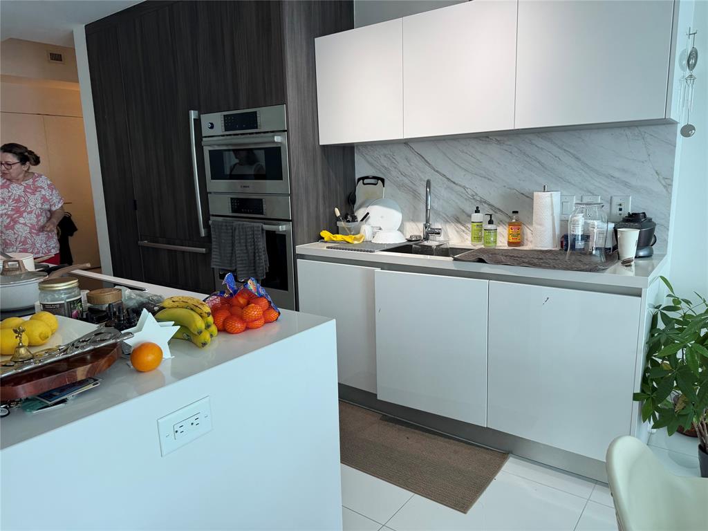 851 Northeast 1st Avenue, Unit 2606 Miami, FL 33132 - Photo 5 of 30 a kitchen with a sink a stove and cabinets