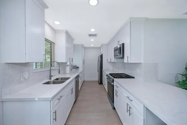 a kitchen with stainless steel appliances a sink stove and cabinets