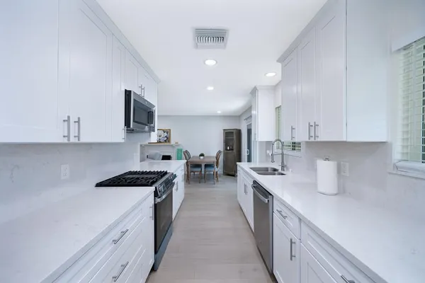 a kitchen with stainless steel appliances a sink stove top oven and cabinets