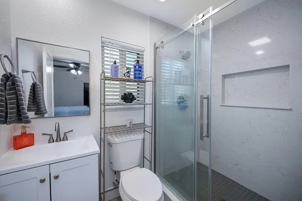 a bathroom with a sink a toilet and shower