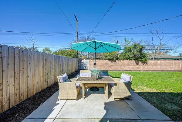 a patio with wooden table and chairs
