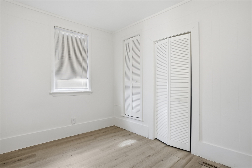43 Wamesit Street Lowell, MA 01852 - Photo 11 of 34 an empty room with wooden floor and windows
