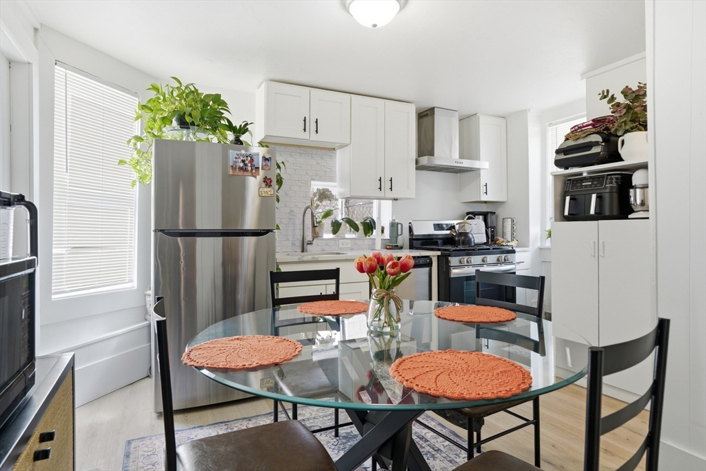 43 Wamesit Street Lowell, MA 01852 - Photo 14 of 34 a kitchen with stainless steel appliances a refrigerator a stove a dining table and chairs