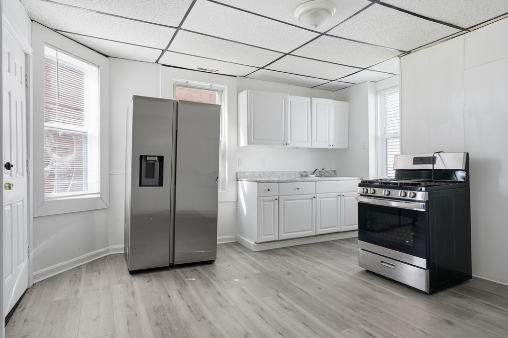43 Wamesit Street Lowell, MA 01852 - Photo 27 of 34 a kitchen with stainless steel appliances granite countertop a refrigerator and a stove top oven