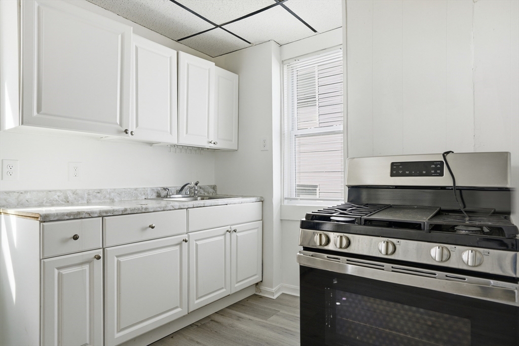 43 Wamesit Street Lowell, MA 01852 - Photo 29 of 34 a kitchen with granite countertop white cabinets and stainless steel appliances