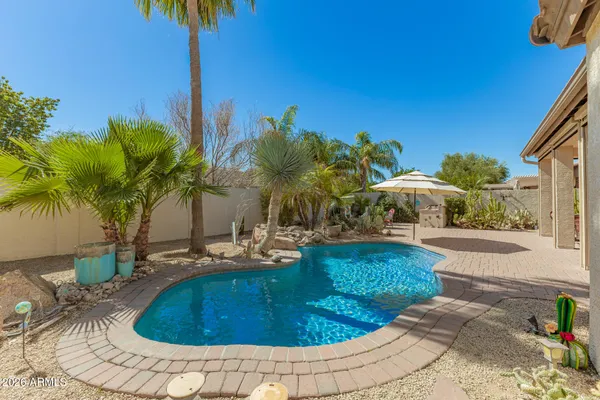 a view of a swimming pool with a patio and a yard