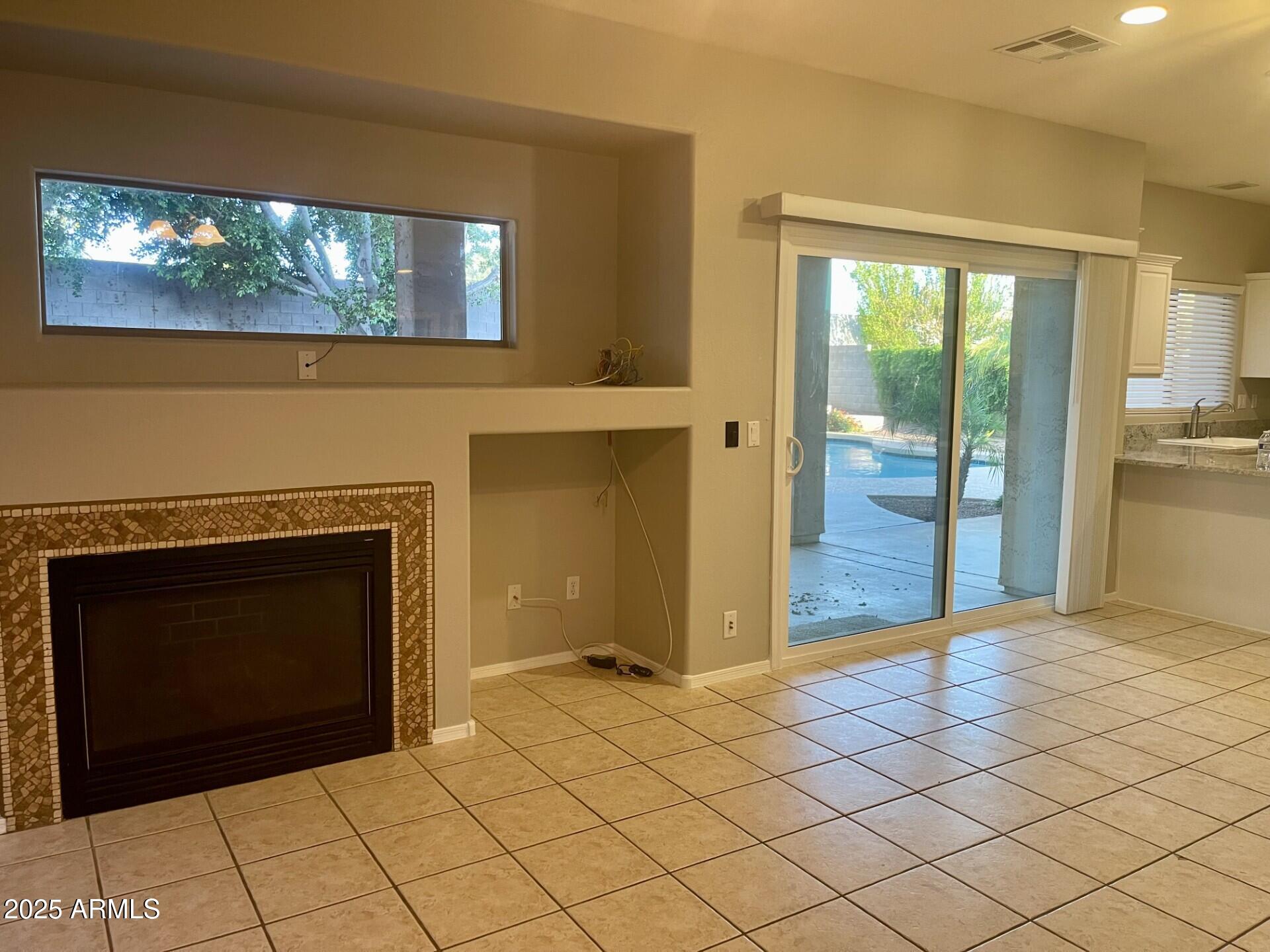 3613 North 127th Drive Avondale, AZ 85392 - Photo 4 of 12 a view of an empty room with wooden floor and fireplace
