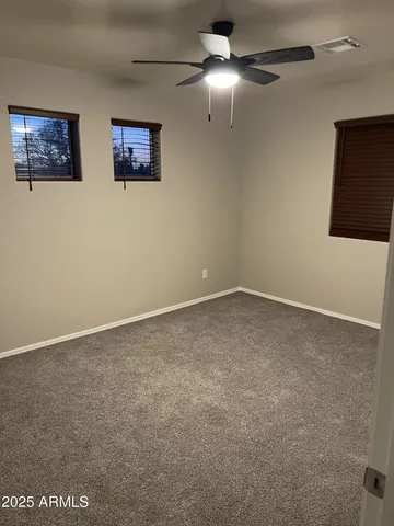 a view of an empty room with a ceiling fan