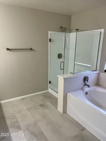 a bathroom with a tub sink a mirror and shower