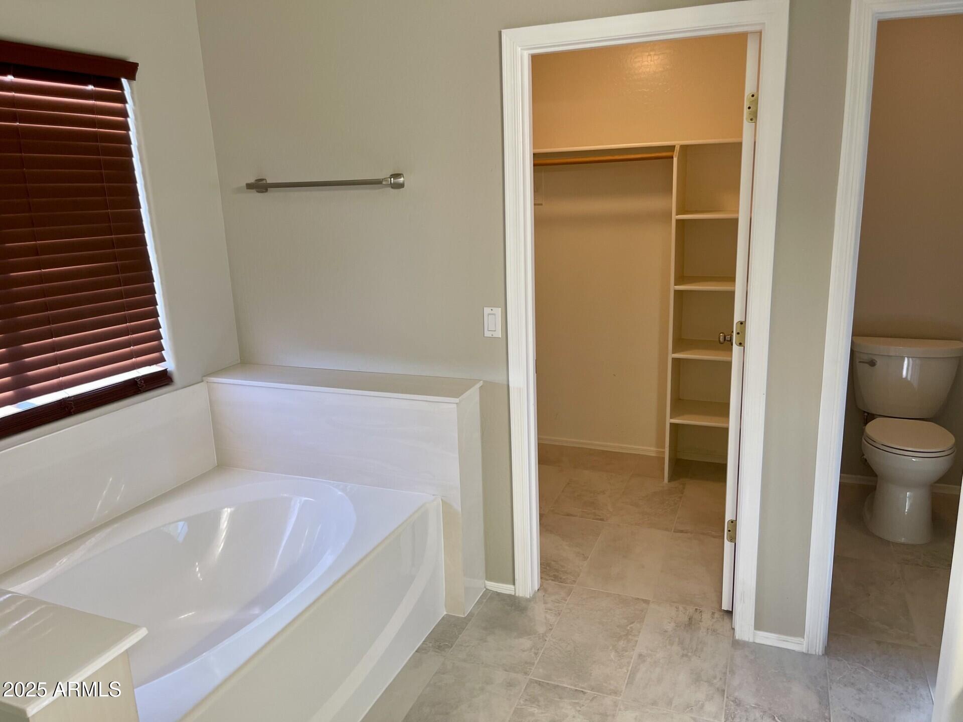 3613 North 127th Drive Avondale, AZ 85392 - Photo 8 of 12 a bathroom with a bathtub and toilet