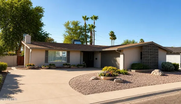 a front view of a house with a yard and potted plants