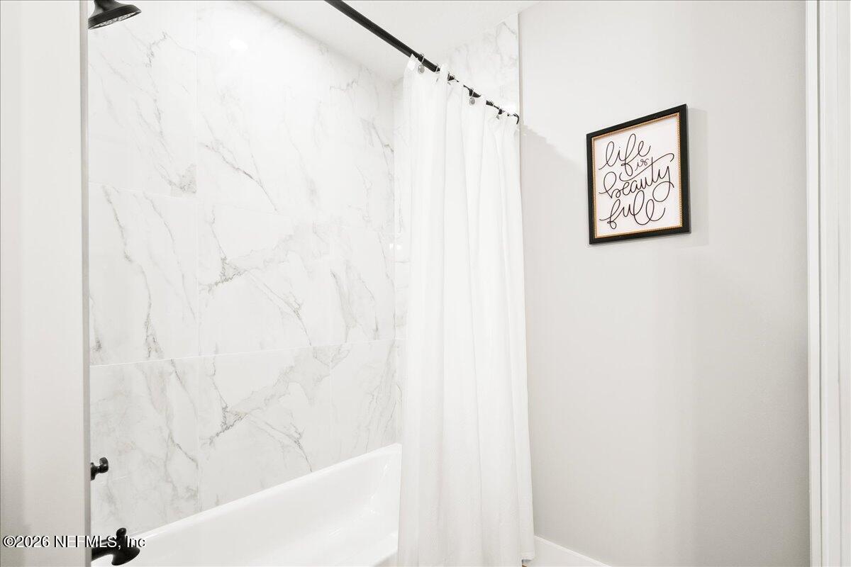 800 9th Street St. Augustine, FL 32084 - Photo 28 of 45 a bathroom with a bathtub and shower