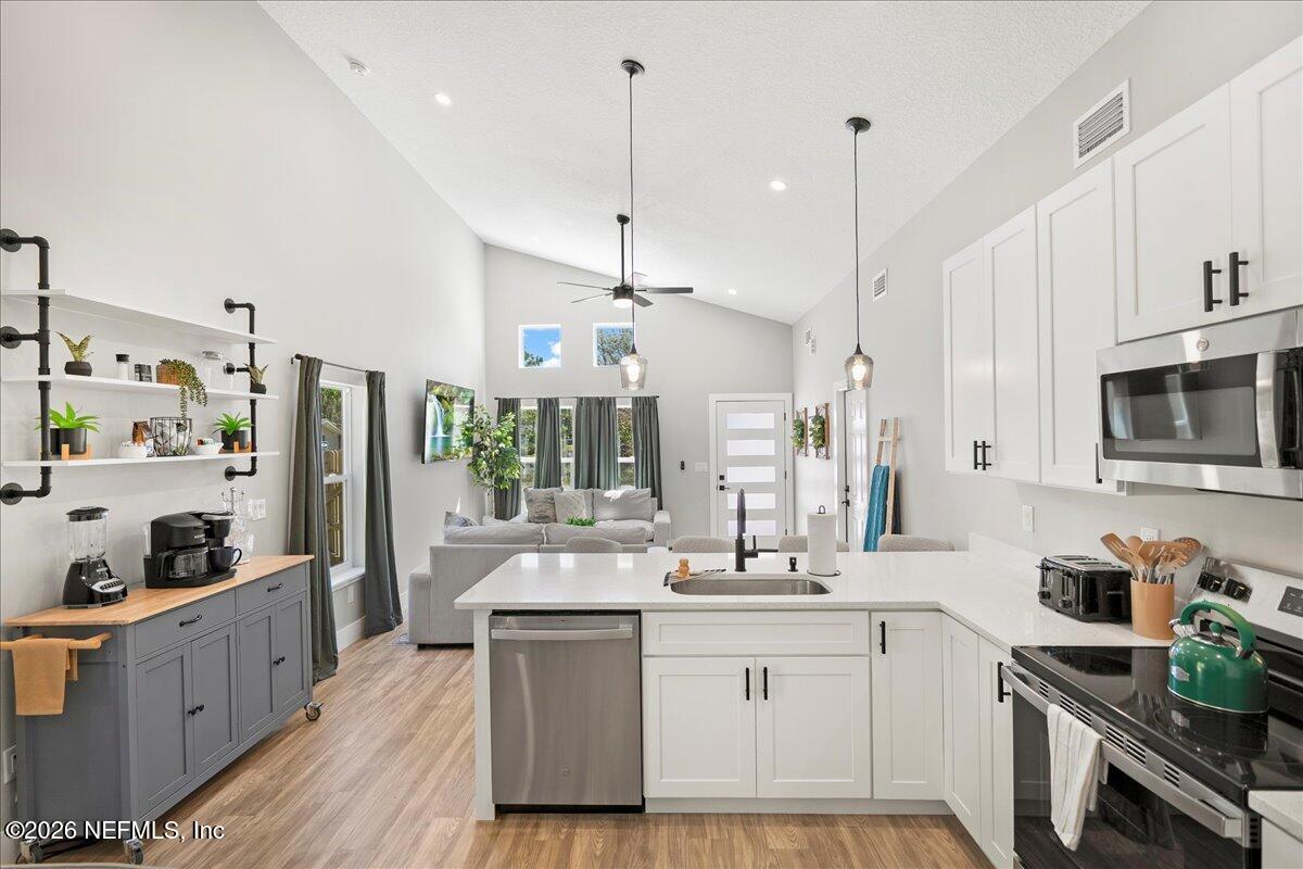 800 9th Street St. Augustine, FL 32084 - Photo 3 of 45 a large white kitchen with lots of counter space and wooden floor