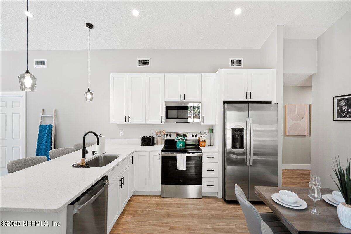 800 9th Street St. Augustine, FL 32084 - Photo 6 of 45 a kitchen with stainless steel appliances a refrigerator sink and cabinets