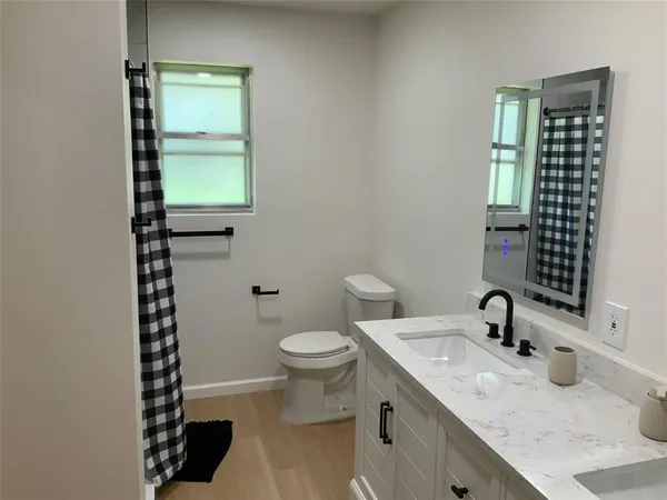 a bathroom with a sink a toilet and a window
