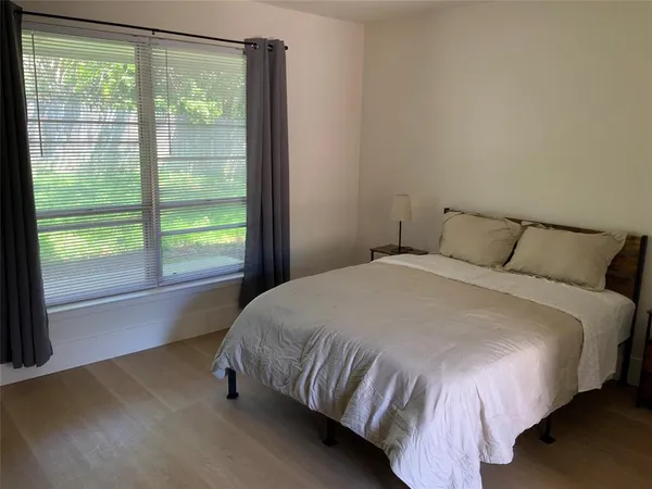 a bed sitting in a bedroom next to a window
