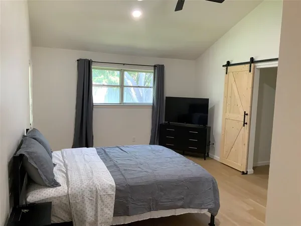 a bedroom with a bed and a television