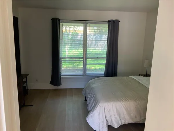a bed sitting in a bedroom next to a window