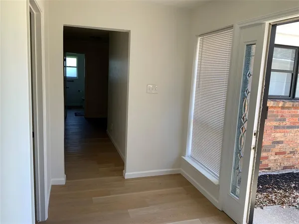 a view of a hallway with wooden floor and closet