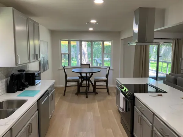 a kitchen with a table chairs sink and cabinets