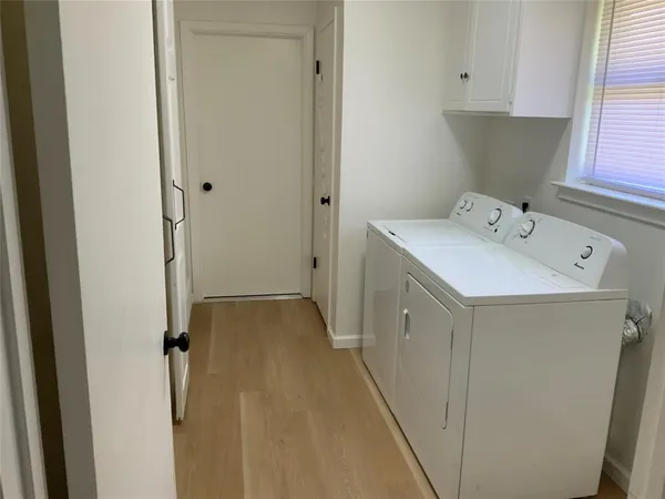 a utility room with cabinets washer and dryer
