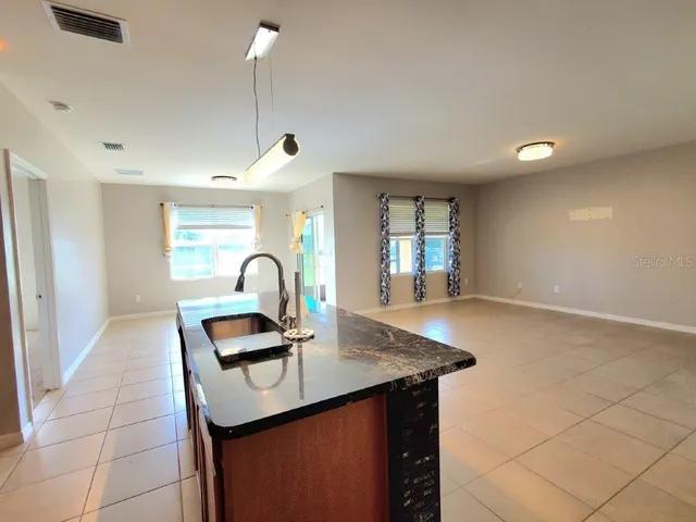 a kitchen with kitchen island a counter top space and a sink