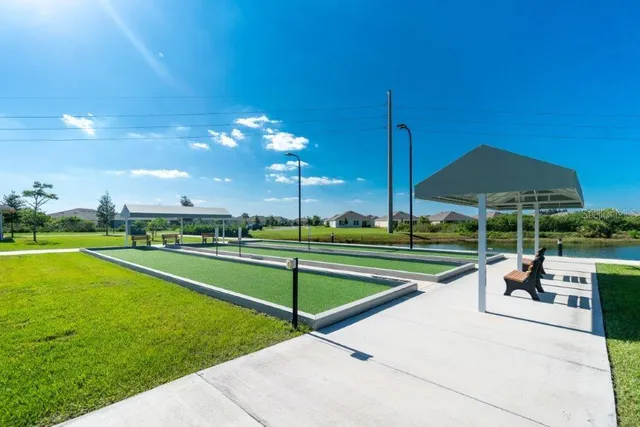 a view of a swimming pool with lawn chairs under an umbrella