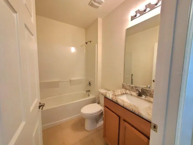 a bathroom with a granite countertop sink toilet a shower and a mirror