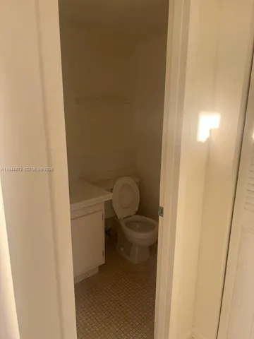 a bathroom with a granite countertop toilet and a sink