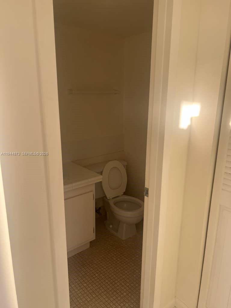 528 Mansfield M, Unit 528 Boca Raton, FL 33434 - Photo 11 of 14 a bathroom with a granite countertop toilet and a sink