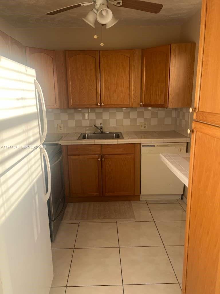528 Mansfield M, Unit 528 Boca Raton, FL 33434 - Photo 4 of 14 a kitchen with a sink a stove cabinets and wooden floor