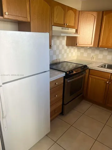 a kitchen with stainless steel appliances granite countertop a refrigerator sink and cabinets