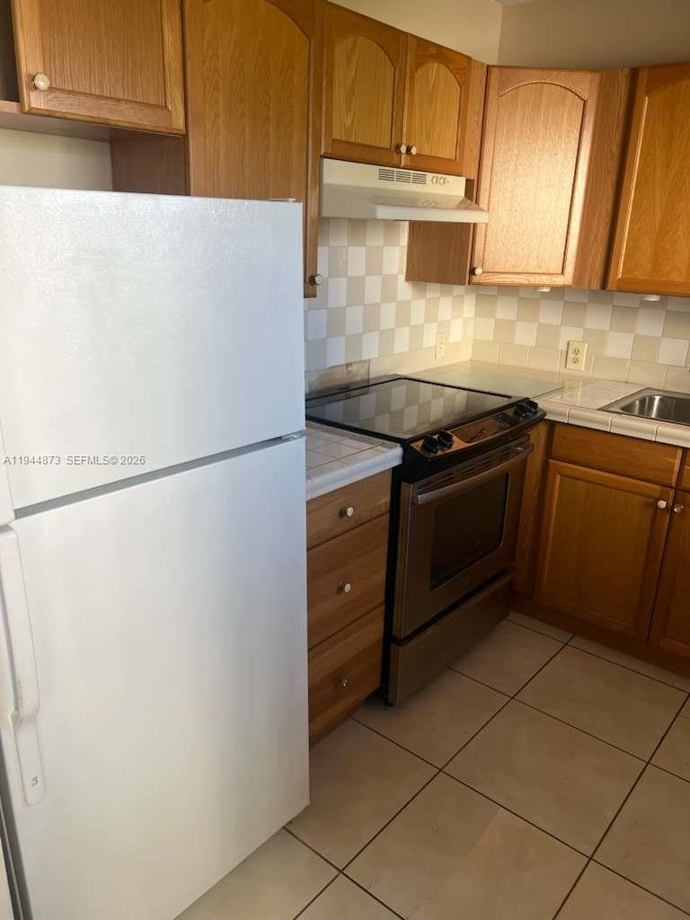 528 Mansfield M, Unit 528 Boca Raton, FL 33434 - Photo 6 of 14 a kitchen with stainless steel appliances granite countertop a refrigerator sink and cabinets