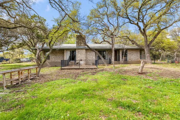 a view of a house with a yard and tree s