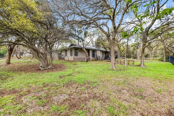 a view of a house with backyard and tree
