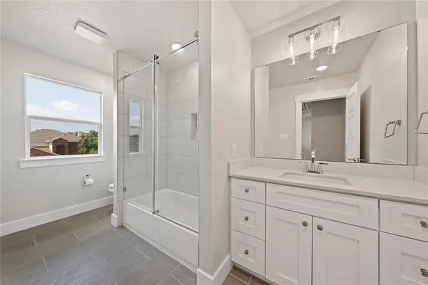 a bathroom with a tub a sink shower and mirror