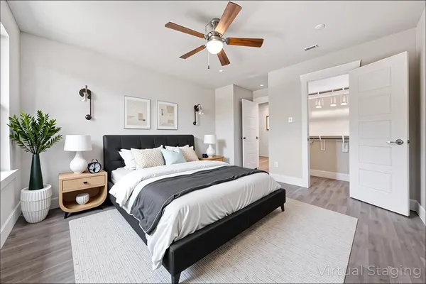 a spacious bedroom with a bed and a potted plant