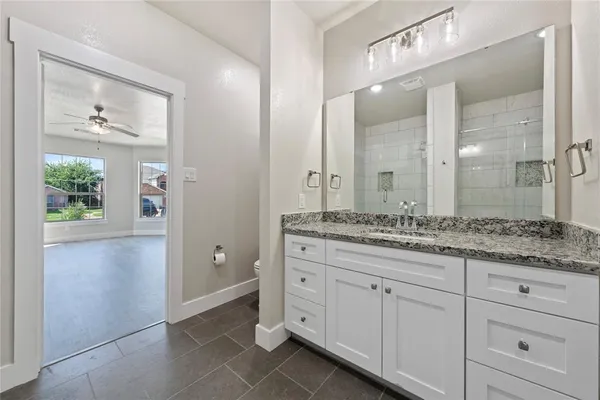a bathroom with a granite countertop sink and a mirror