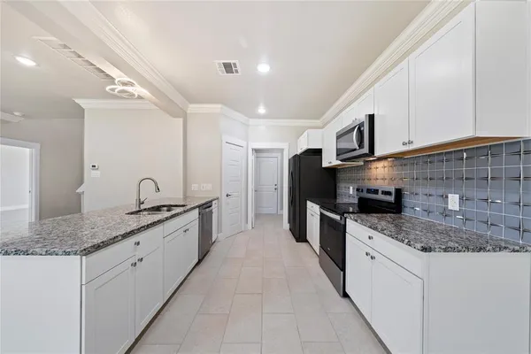 a large kitchen with stainless steel appliances granite countertop a sink stove and cabinets