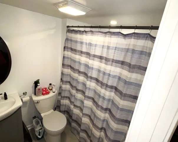a bathroom with a toilet and a shower curtain