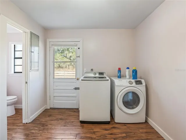a view of a house with a yard and large tree
